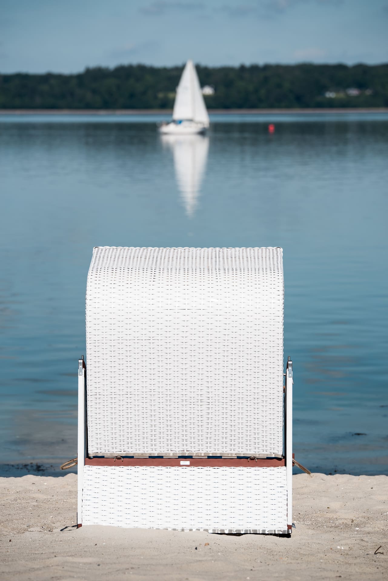Strandkorb von hinten, Blickrichtung Wasser mit kleinem Segelboot
