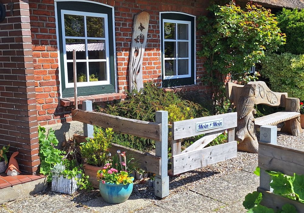 Blick auf geöffnete Gartenpforte vor Rotklinkerhaus